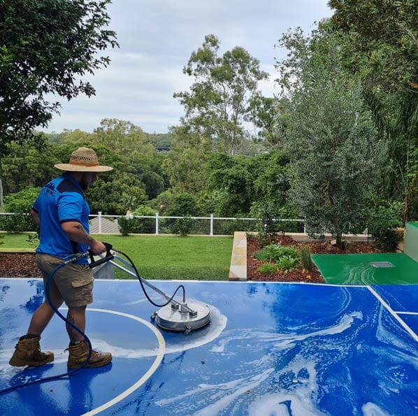 a man washing a court floor